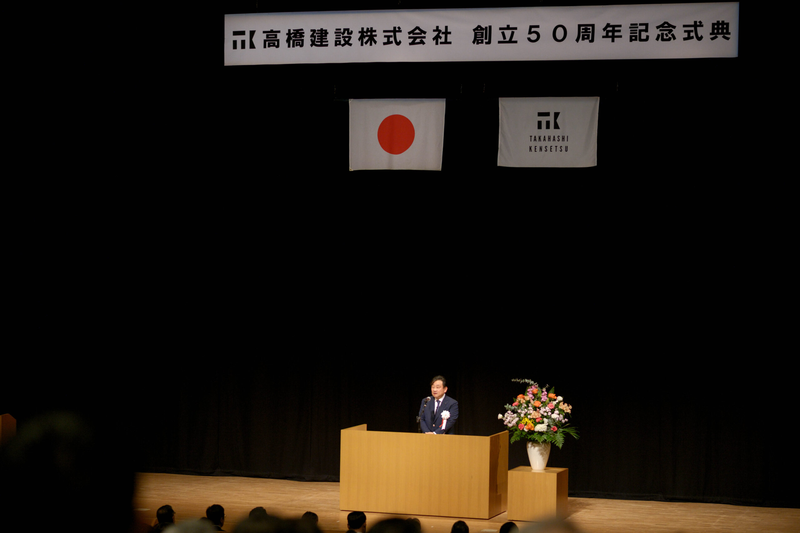 alt=“創業50周年式典で挨拶する高橋建設代表取締役”